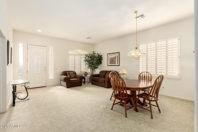 carpeted dining space with baseboards, recessed lighting, visible vents, and a chandelier