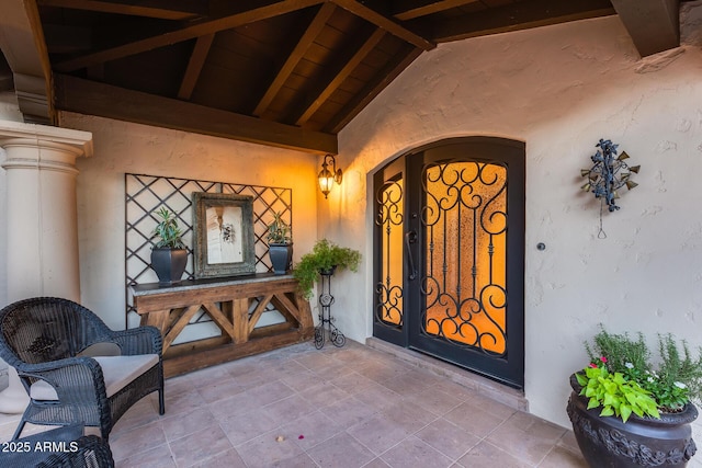 view of exterior entry featuring stucco siding and covered porch
