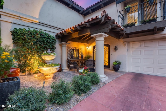 doorway to property featuring stucco siding and a tile roof