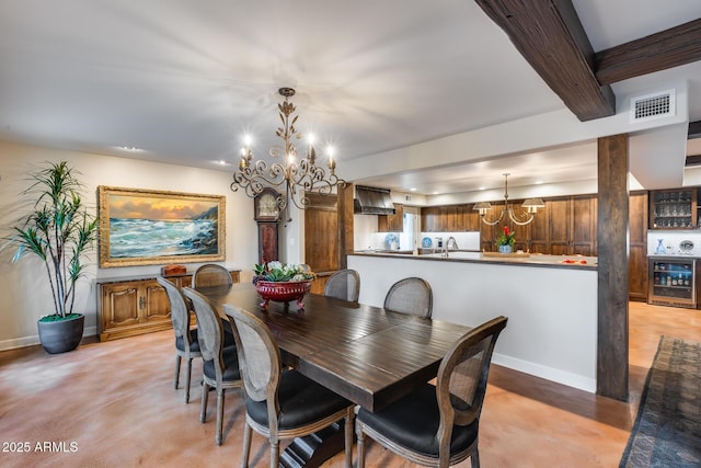 dining room with beverage cooler, a chandelier, and baseboards