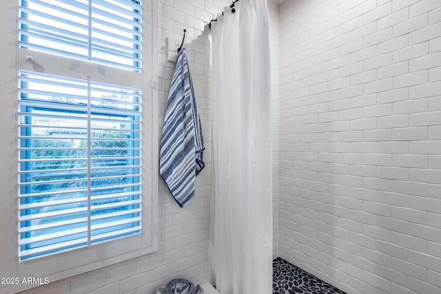 bathroom with tiled shower and healthy amount of natural light