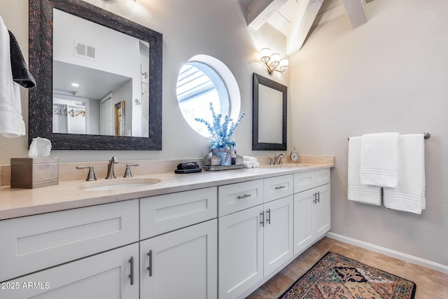 bathroom with double vanity and baseboards