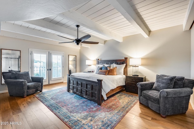 bedroom featuring access to outside, beamed ceiling, hardwood / wood-style flooring, wood ceiling, and a ceiling fan
