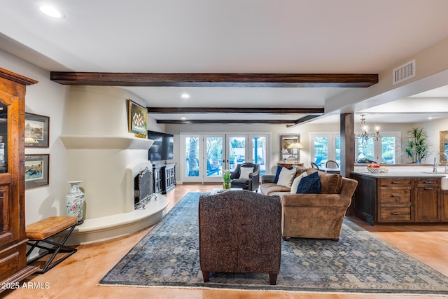 living room with beam ceiling, healthy amount of natural light, a fireplace with raised hearth, recessed lighting, and french doors