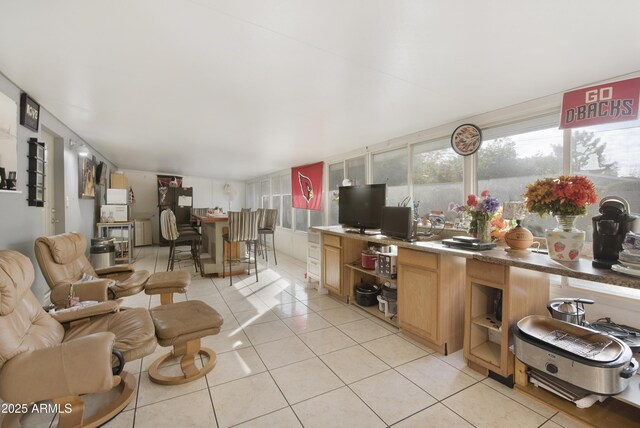 kitchen featuring light tile patterned floors and black fridge