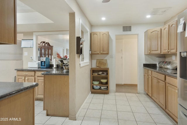 kitchen with light brown cabinets and light tile patterned flooring