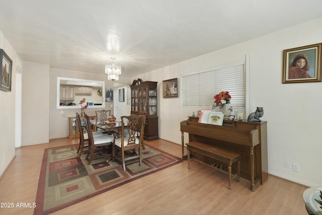 dining area featuring an inviting chandelier and light hardwood / wood-style flooring