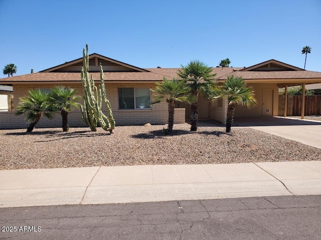 view of front of home featuring driveway, an attached carport, and fence