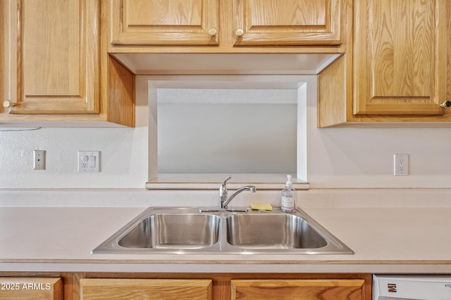 kitchen with a sink, light countertops, dishwasher, and light brown cabinets