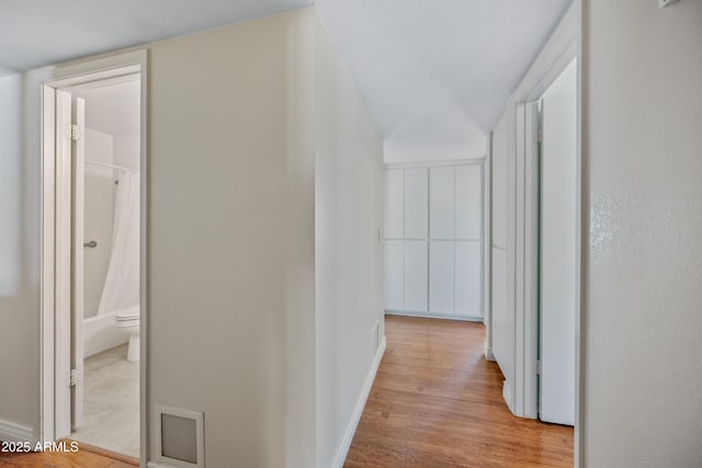 hallway with wood finished floors and baseboards
