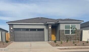 25235 N 183rd Dr, Wittmann, AZ 85361 - prairie-style home with driveway, an attached garage, and stone siding