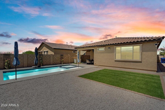 pool at dusk featuring a patio