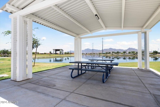 view of patio / terrace with a water and mountain view