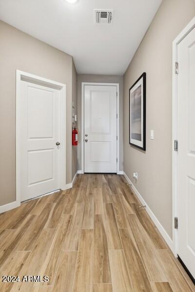 entryway featuring light wood-style flooring, baseboards, and visible vents