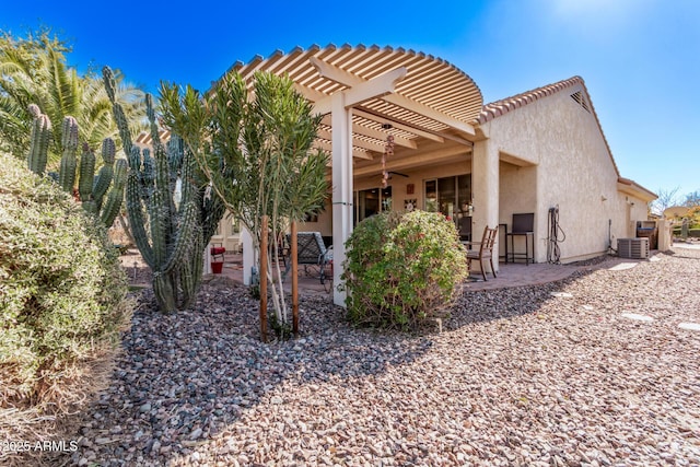 rear view of property featuring a patio, central air condition unit, and a pergola