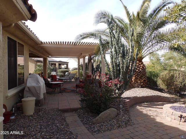 view of patio with area for grilling and a pergola