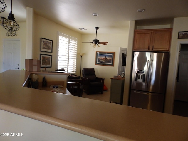 kitchen with ceiling fan, stainless steel fridge, and hanging light fixtures