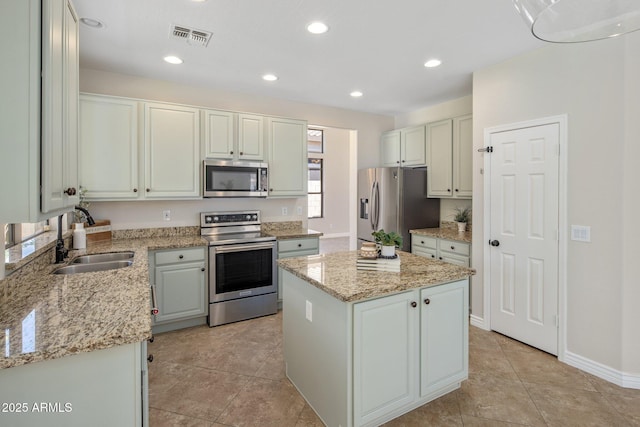 7758 E Nestling Way, Scottsdale, AZ 85255 - kitchen with appliances with stainless steel finishes, a sink, a center island, light stone countertops, and recessed lighting