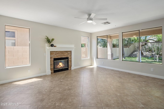 7758 E Nestling Way, Scottsdale, AZ 85255 - unfurnished living room with ceiling fan, tile patterned floors, a stone fireplace, and baseboards