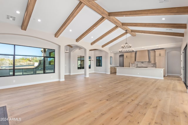 unfurnished living room featuring beamed ceiling, a chandelier, high vaulted ceiling, and light hardwood / wood-style flooring