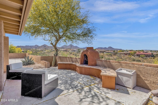 view of patio / terrace featuring an outdoor living space with a fireplace, fence, and a mountain view