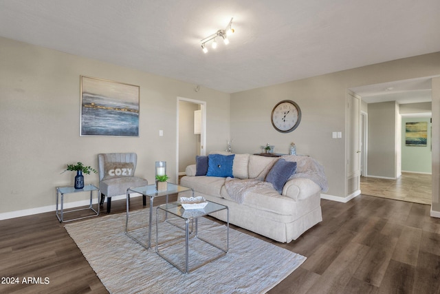 living area featuring dark wood-style flooring and baseboards