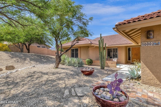 exterior space with a patio area, a tile roof, fence, and stucco siding