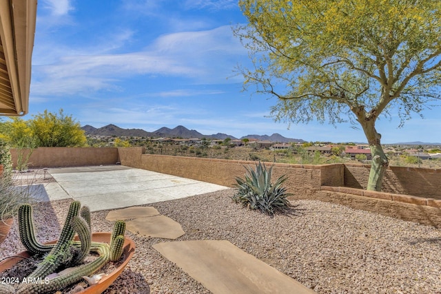 view of yard featuring a patio area, a mountain view, and fence