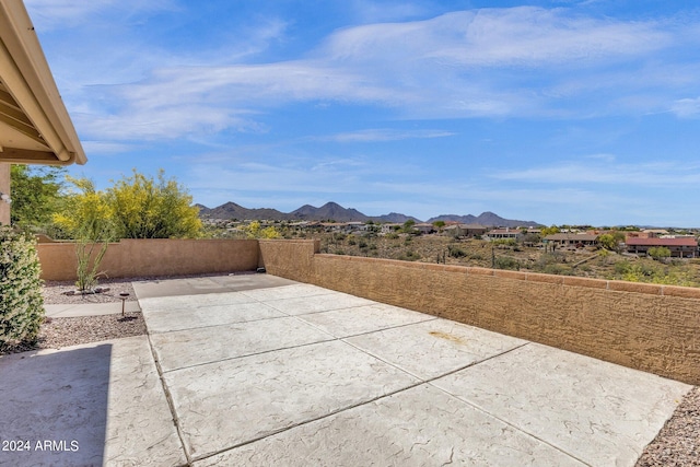 view of patio with fence and a mountain view