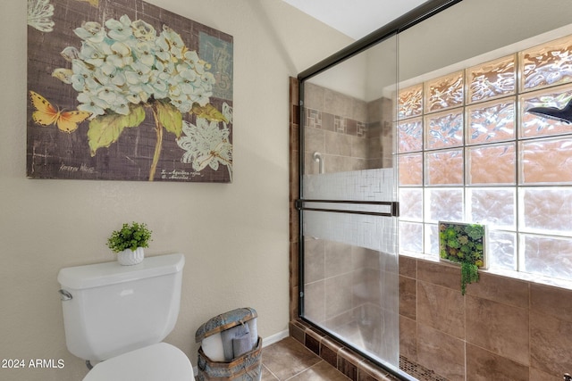 full bathroom with toilet, tile patterned flooring, and tiled shower