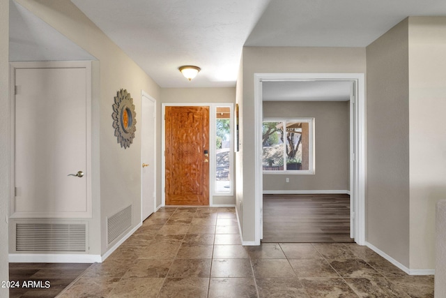 foyer entrance with visible vents and baseboards