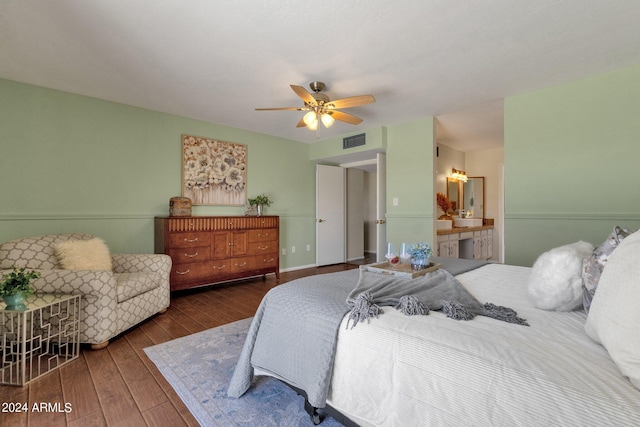 bedroom with hardwood / wood-style floors, ensuite bath, visible vents, and a ceiling fan