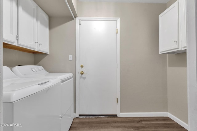 washroom with cabinet space, baseboards, separate washer and dryer, and wood finished floors