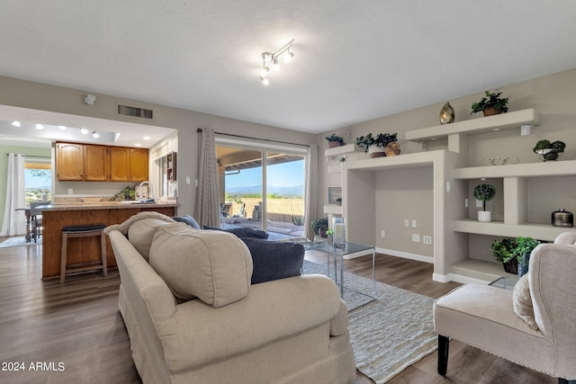 living room featuring baseboards, visible vents, and wood finished floors