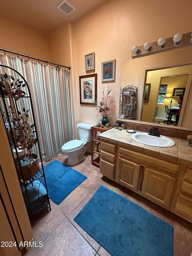 bathroom with toilet, tile patterned flooring, and vanity