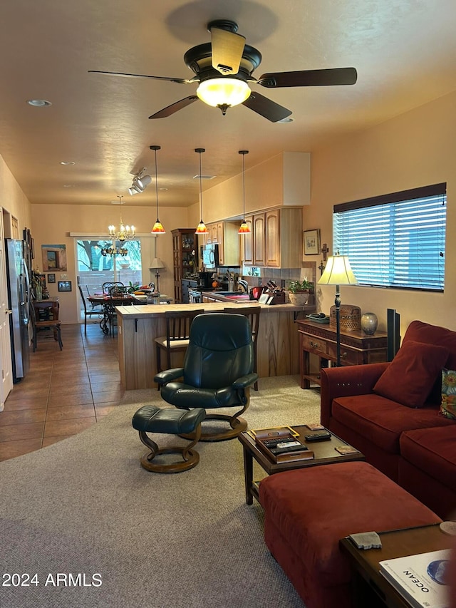 living room with ceiling fan with notable chandelier, tile patterned floors, and a wealth of natural light