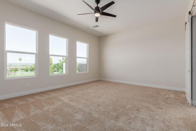 unfurnished room featuring visible vents, ceiling fan, light carpet, and baseboards