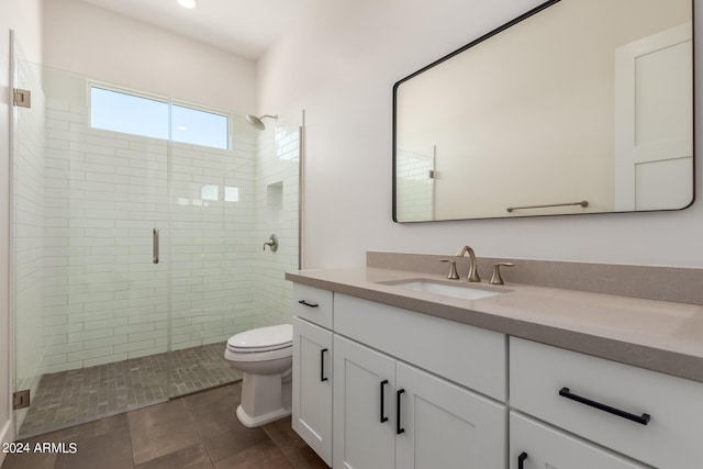 bathroom featuring a stall shower, vanity, and toilet