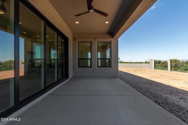 view of patio with ceiling fan and fence