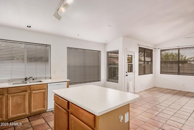 kitchen featuring dishwasher, a kitchen island, light countertops, and a sink
