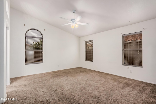 carpeted spare room with a ceiling fan and lofted ceiling