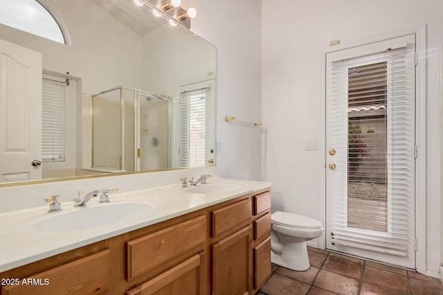 full bath featuring a sink, toilet, double vanity, and a shower stall