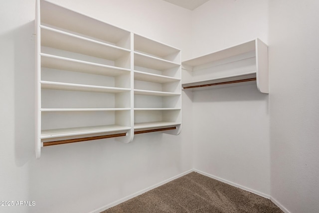 spacious closet featuring dark carpet