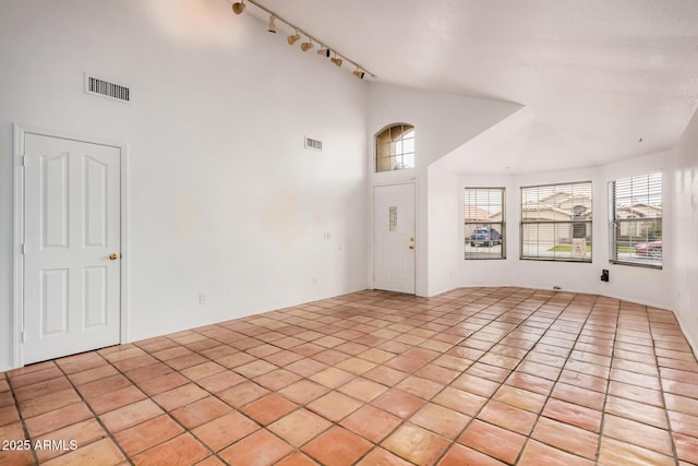 interior space with visible vents, high vaulted ceiling, and track lighting