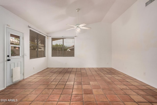 empty room featuring vaulted ceiling, light tile patterned floors, a ceiling fan, and visible vents