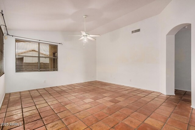 spare room featuring visible vents, arched walkways, tile patterned flooring, ceiling fan, and vaulted ceiling