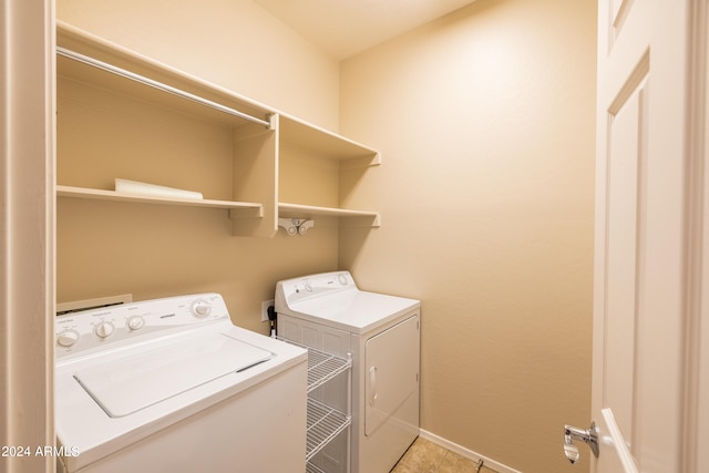 clothes washing area with washing machine and clothes dryer and light tile floors