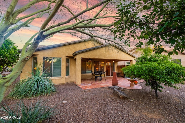 back house at dusk with a patio