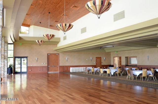 misc room with hardwood / wood-style flooring, a towering ceiling, and french doors