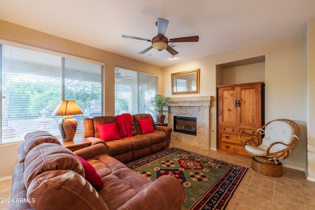 tiled living room with ceiling fan and a fireplace